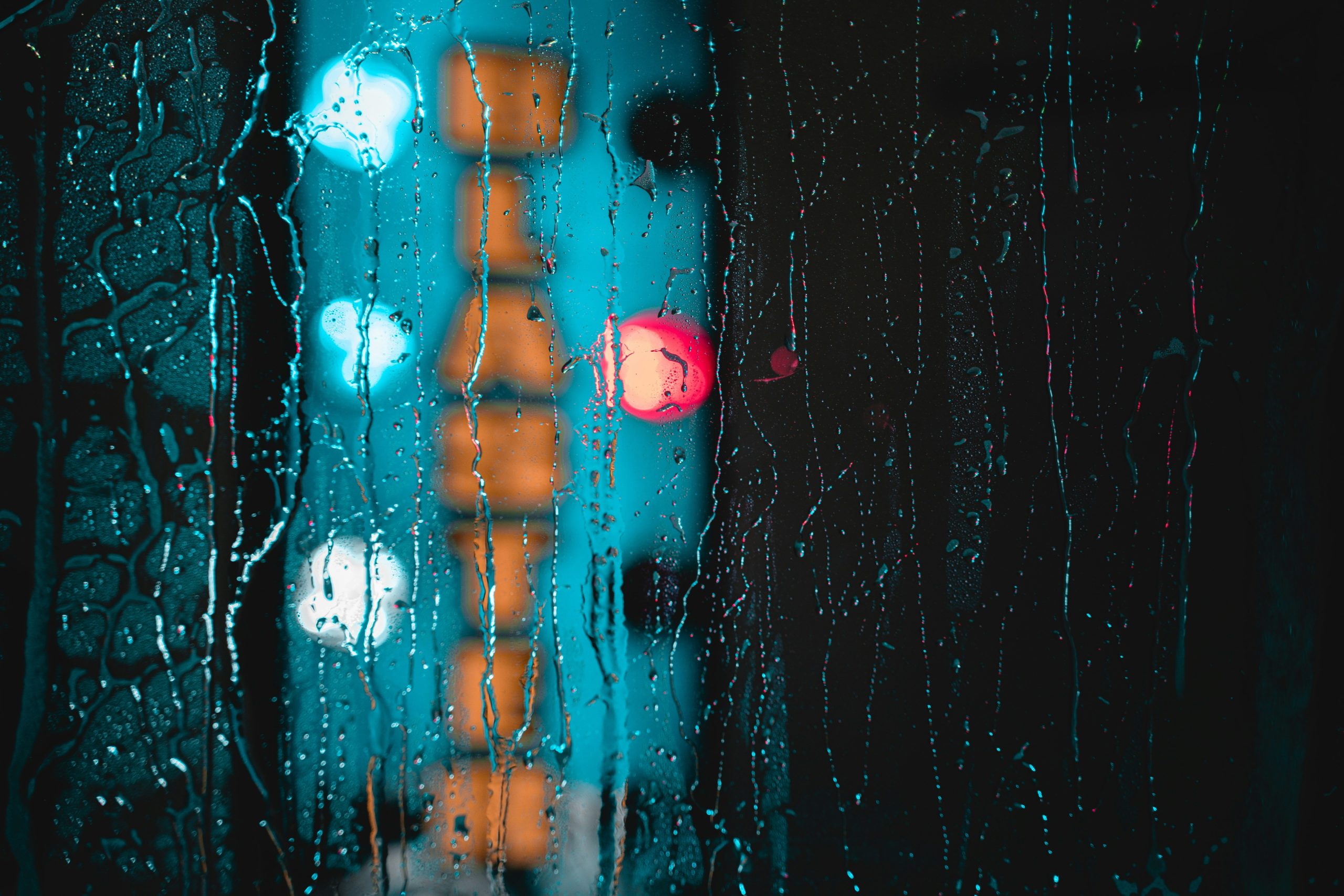 A traveler pulling a neon green rain cover over their backpack during a light drizzle.
