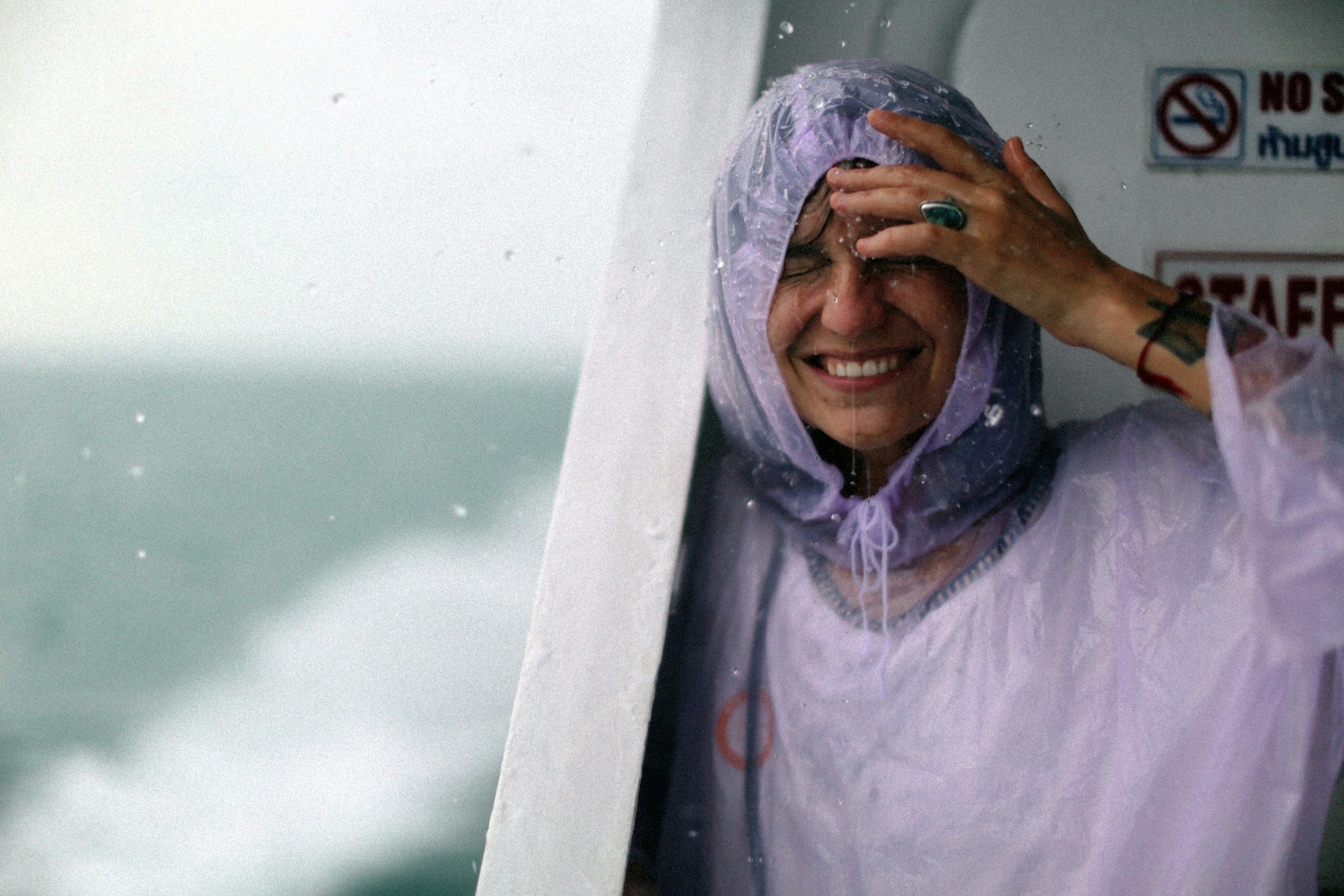 traveler holding soaked clothing after sudden rainstorm